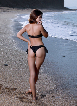 На пляже привлекательная девушка с очаровательным бёдрами