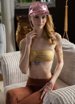 Рыжеволосая девушка с татуировками разделась до гола